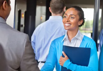 Professional young woman greeting someone at a networking event