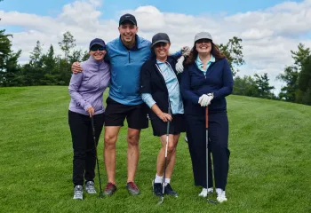 A group photo of four golfers on a course