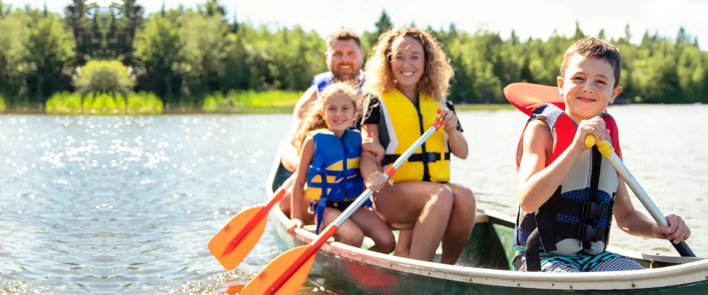 Family of four canoeing on a sunny day