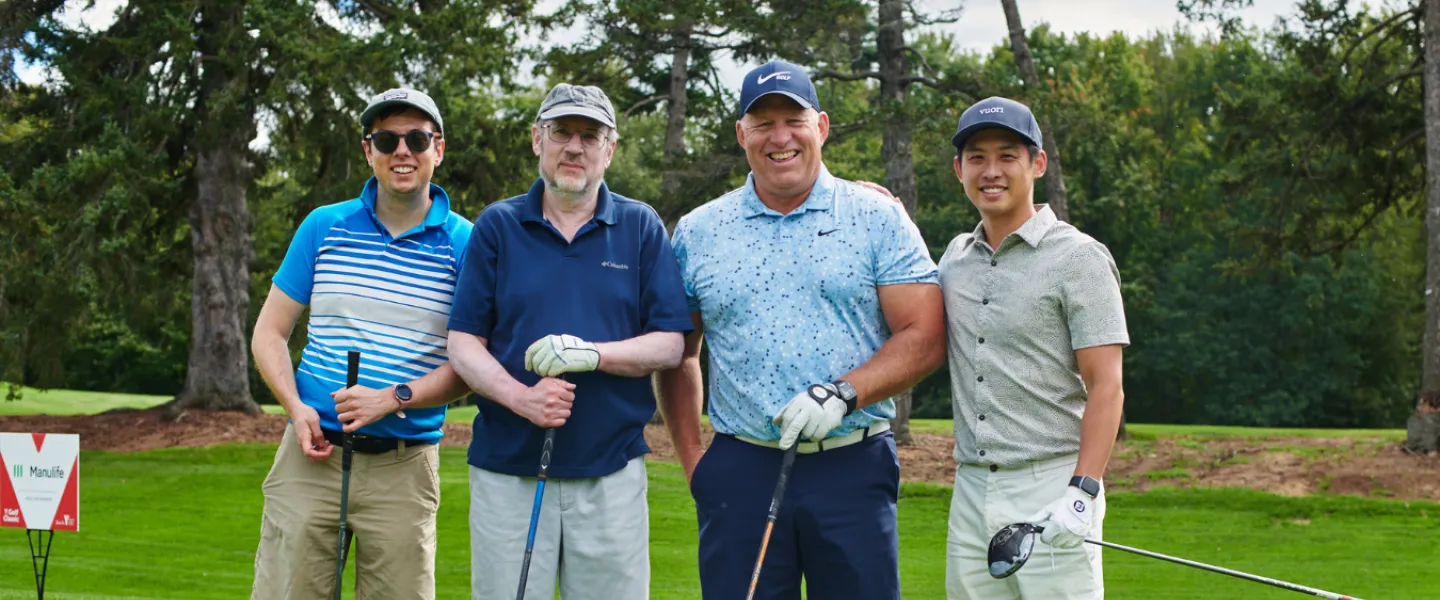 A group photo of four golfers on a course
